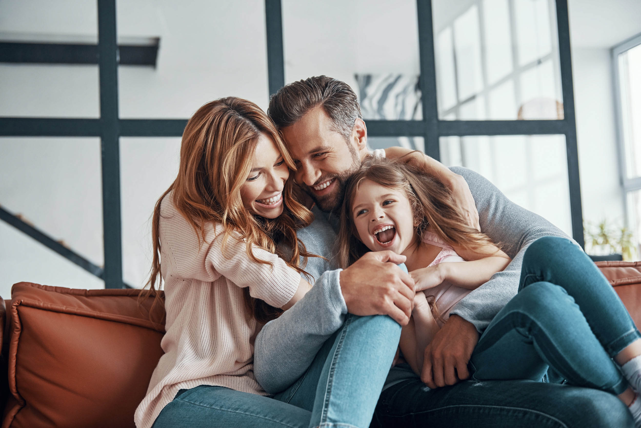 Happy young family smiling and embracing while bonding together